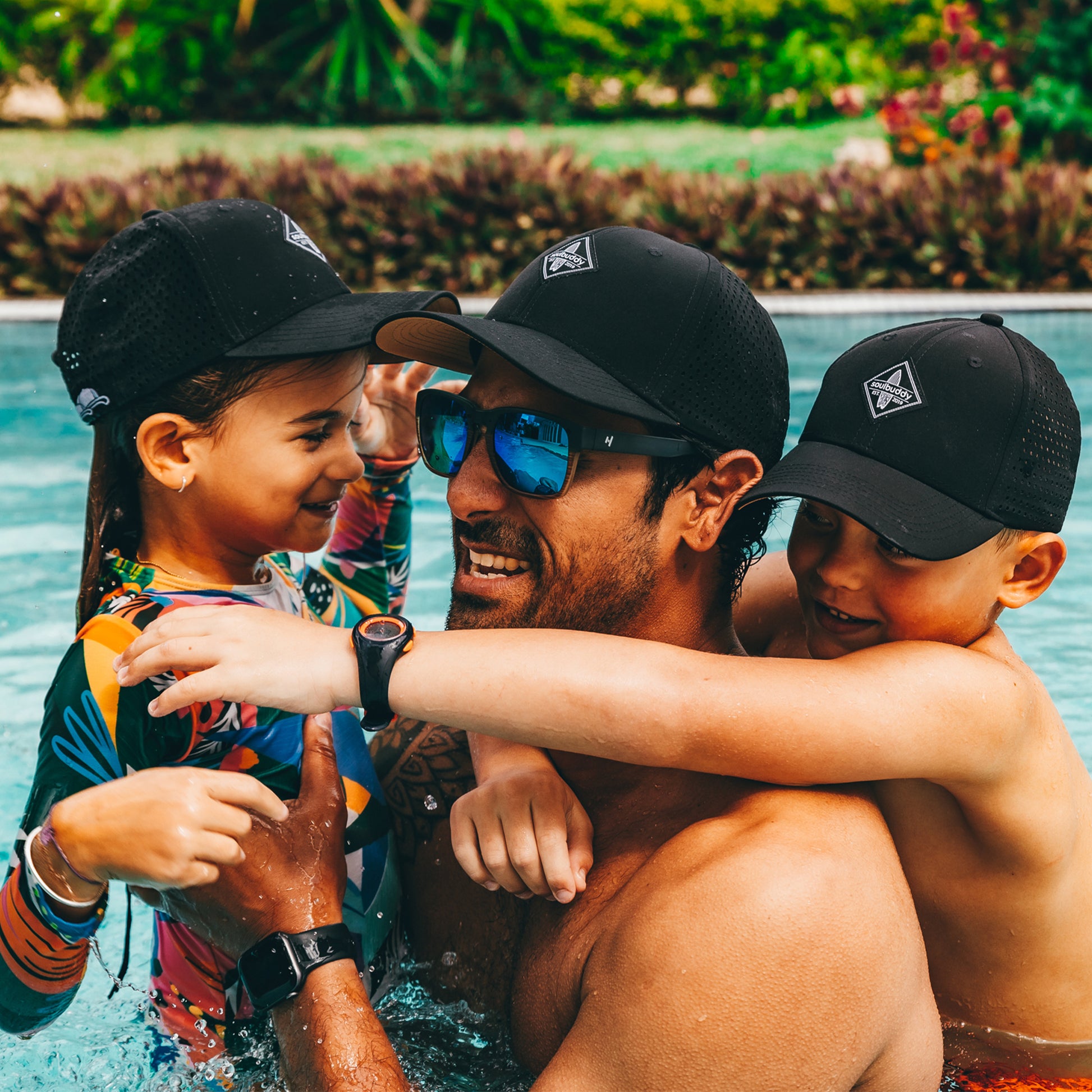 Soulbuddy Sorts Cap 3er-Set Schwarz Vater und Kinder im Pool