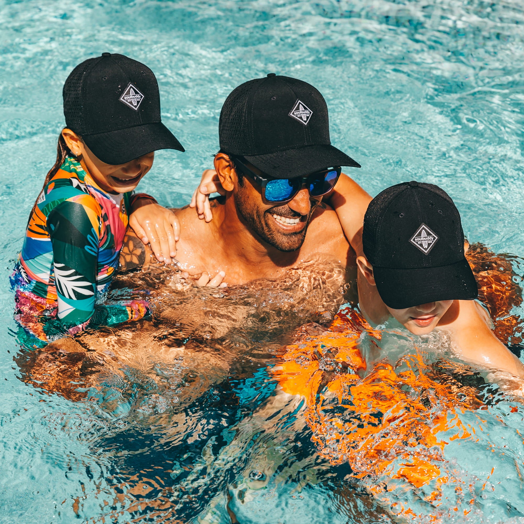 Soulbuddy Sorts Cap 3er-Set Schwarz Vater und Kinder im Pool