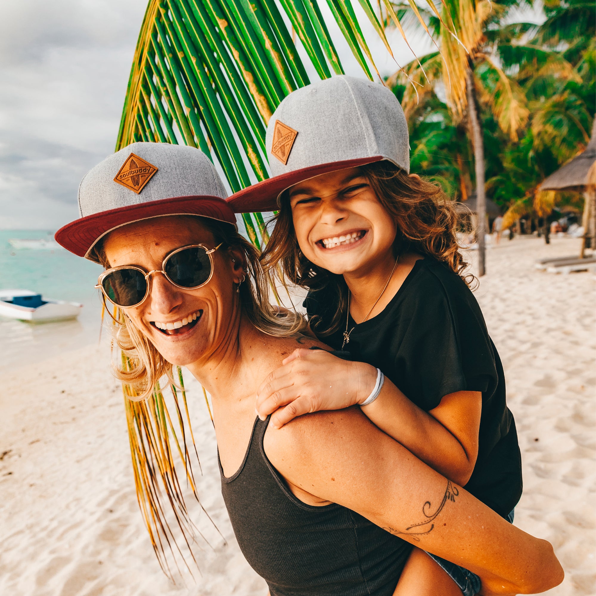 Mutter und Tochter tragen Caps am Strand