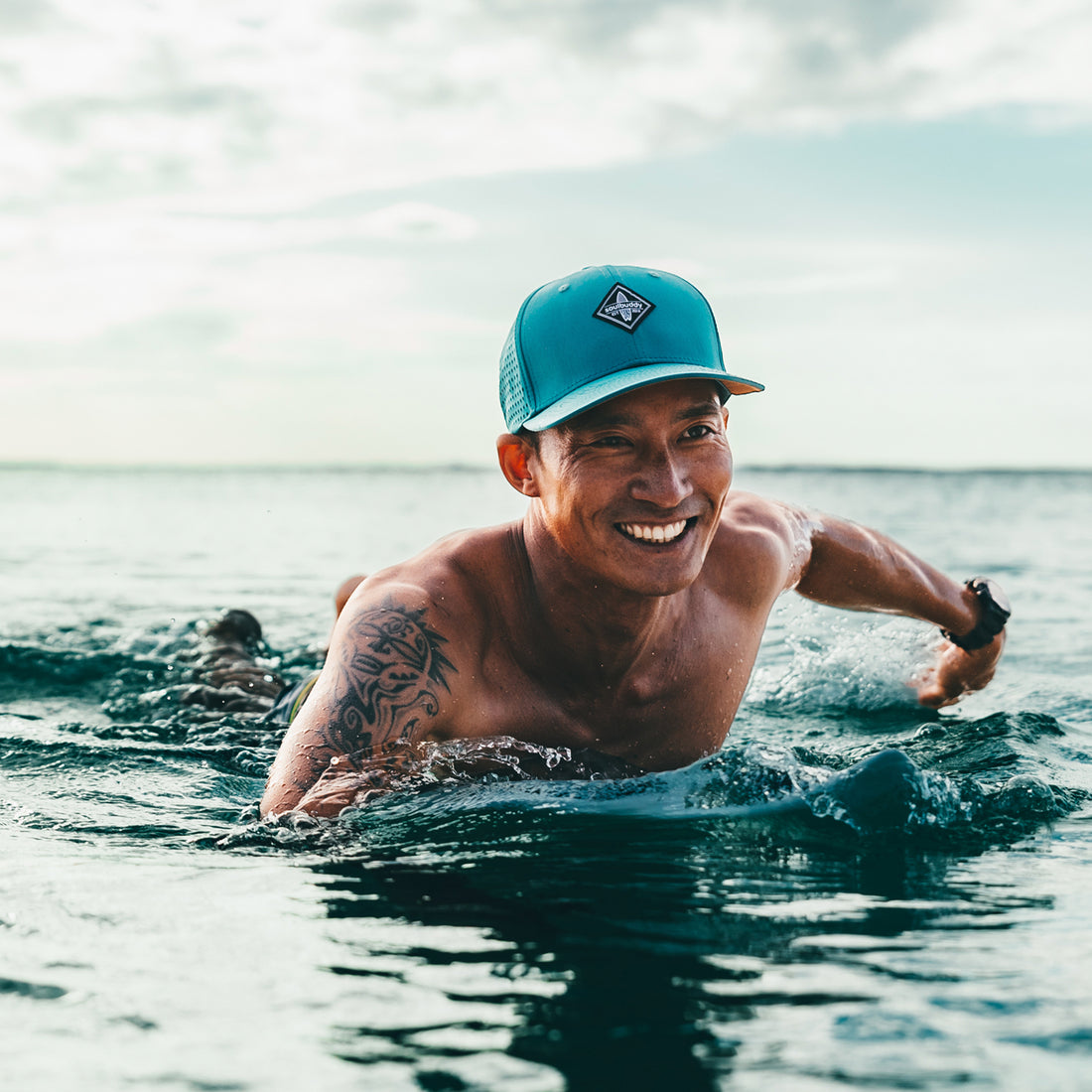 Mann trägt petrol-farbene Sports Cap beim Surfen